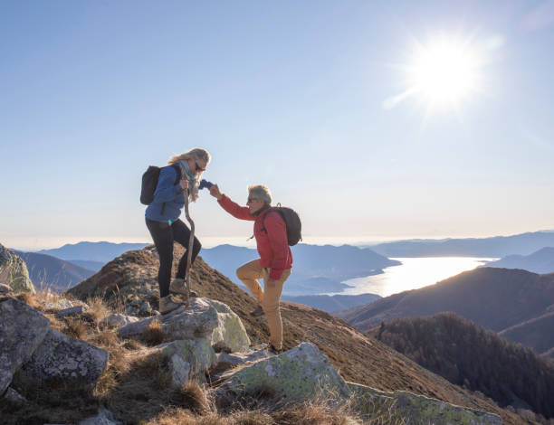 istock Mature couple hike up sunny mountain ridge 1300697090