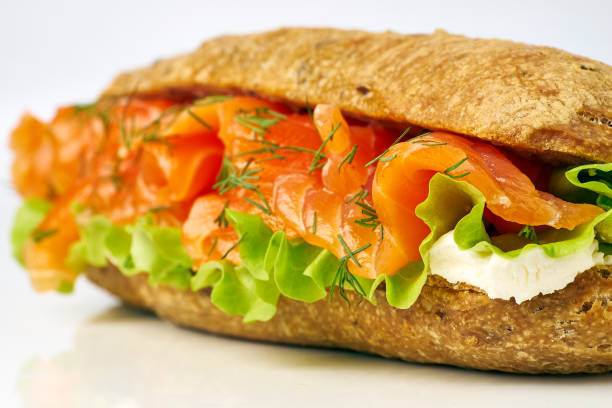 Yummy salmon sandwich close up on white. Selective focus