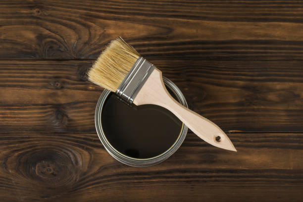 istock Brush on an open jar with a tinting composition on a wooden background. 1300700727