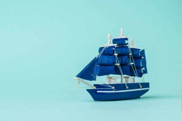 istock Image of a model sailboat on a light blue background. 1300700746