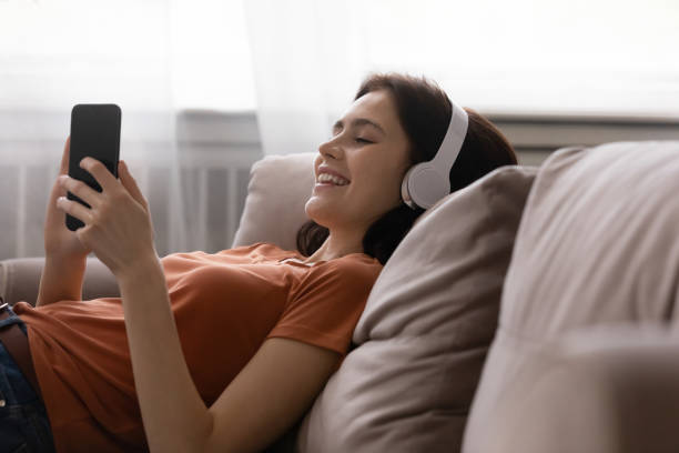 istock Young female student spending free time using cellphone and earphones 1300701435
