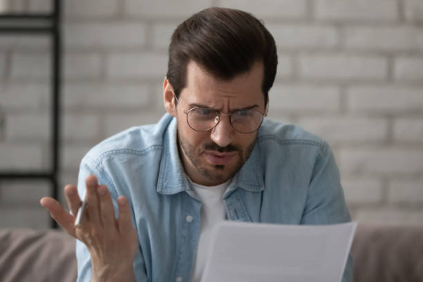 istock Nervous young businessman studying report feeling annoyed with low sales 1300701484