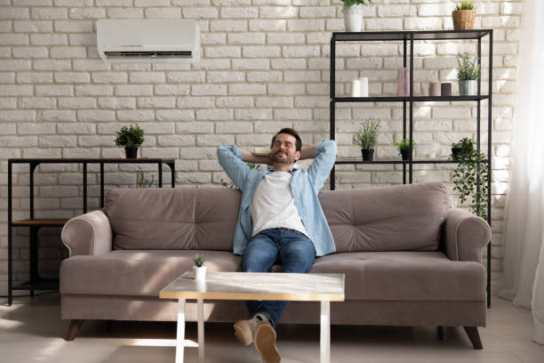 istock Serene young guy enjoying breathing cool fresh air using conditioner 1300701518