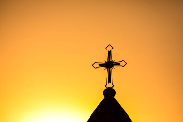 A Silhouette of a cross with evening light sky