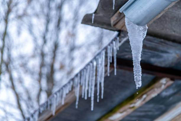 icicle pende sul tetto e si scioglie - beauty in nature bright building exterior close up foto e immagini stock