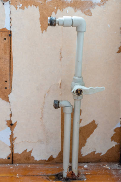 istock Old PVC Plastic Water Pipes for Radiator Circulation System Room remodeling Process with White Grunge Wall for Copy Space 1300703460
