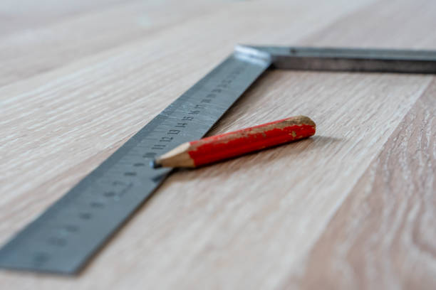 istock Red Carpenter's Pencil and Right Angle's Tool on Laminate Floor after Renovation or Reconstruction Work. DIY Project 1300703465