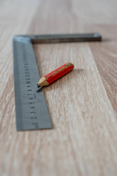 istock Red Carpenter's Pencil and Right Angle's Tool on Laminate Floor after Renovation or Reconstruction Work. DIY Project 1300703468