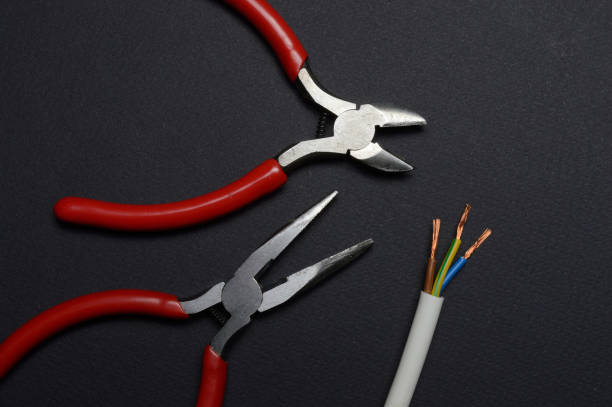 istock wire cutters, pliers and stripped wire lie against a dark background. close-up. 1300704306