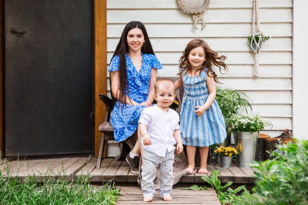 istock Smiling woman with cute kids on terrace 1300704804