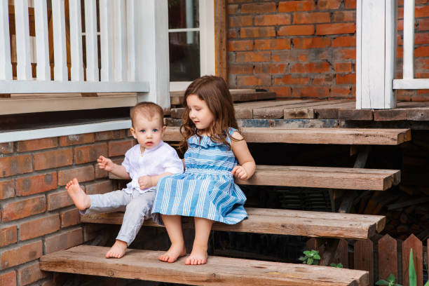 istock Content siblings on wooden stairs 1300705676