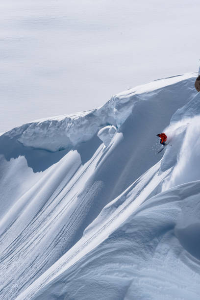 istock Backcountry skier descends snow slope in mountains 1300705706
