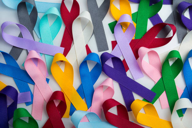 多色癌リボンの背景。世界のがんの日のために患者、サポーター、生存者が誇らしげに着用。あらゆる種類のがんに対する意識を高める - 生存 ストックフォトと画像