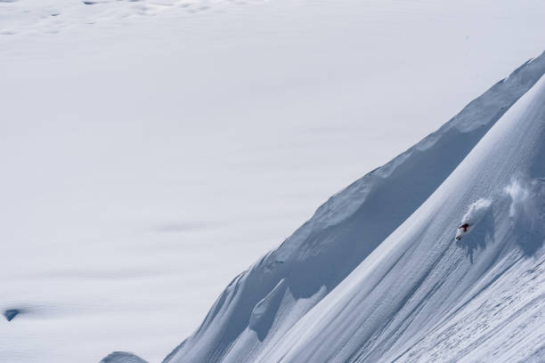 istock Backcountry skier descends snow slope in mountains 1300705885