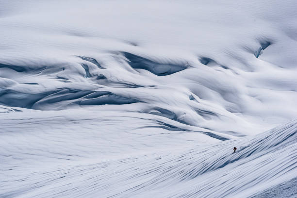 istock Backcountry skier descends snow slope in mountains 1300706614
