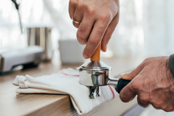 homme apprivoisant le café frais de matin - tamping photos et images de collection