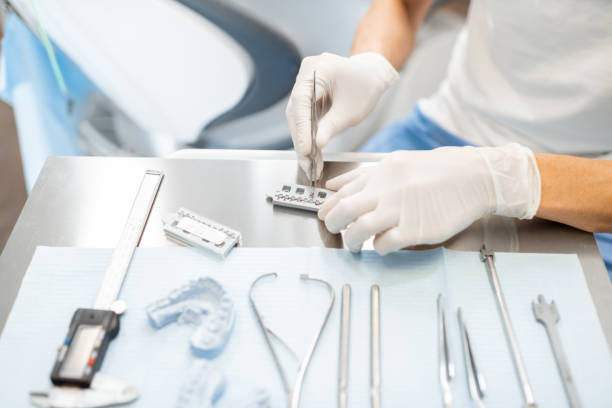 istock Orthodontist working with jaw model applying brace system 1300712615