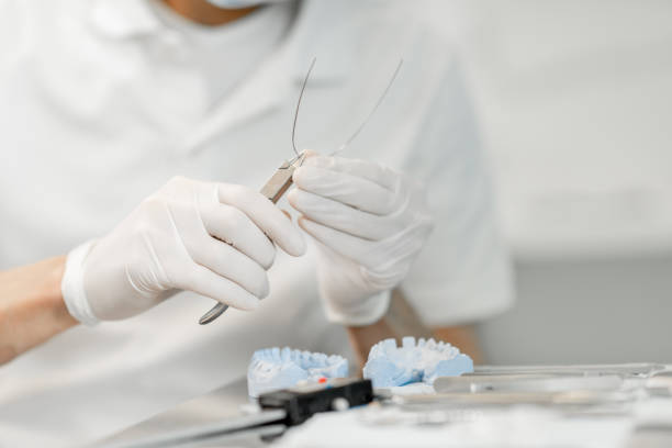 istock Dental technician working with a model of teeth and dental braces 1300713484