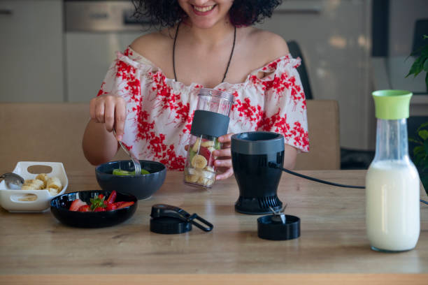 istock Woman making healthy smoothie in the kitchen 1300716605