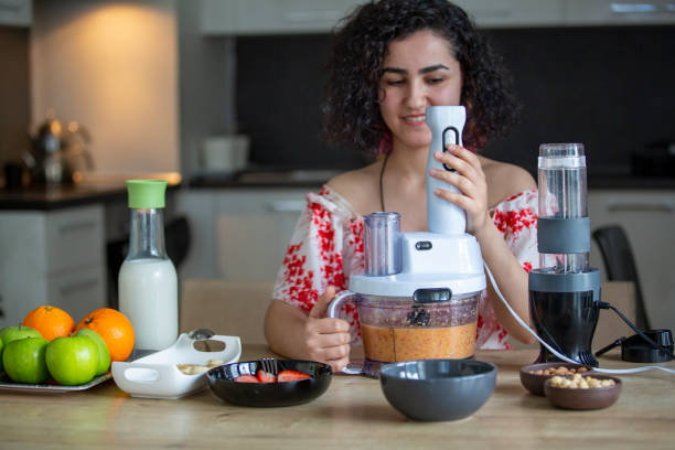 close-up of woman making smoothie with fruits - blender apple banana color image imagens e fotografias de stock