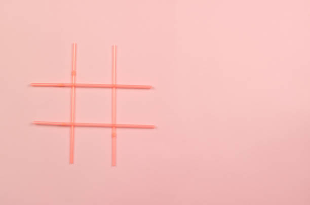 istock Hashtag symbol of pink plastic drink straws on pink background 1300717151