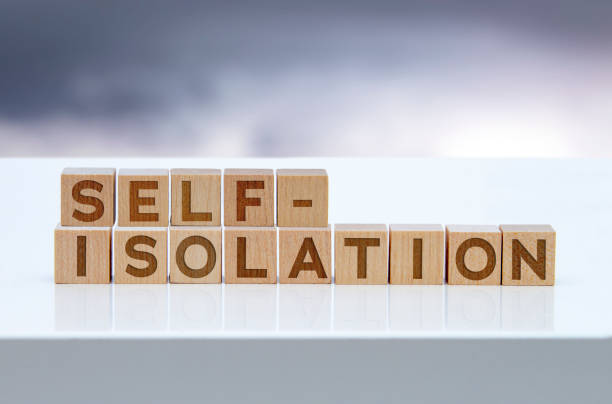 istock 'Self-isolation' message sign on wooden blocks sitting on a white table. 1300718080