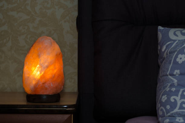 Himalayan pink salt lamp on the bedside table in the bedroom.