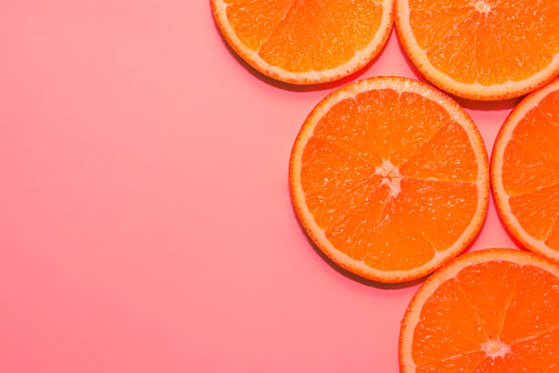 istock Sliced ripe oranges on a bright pink background. 1300718217