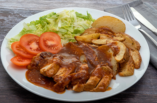 Roast chicken with barbecue sauce, potato wedges and salad