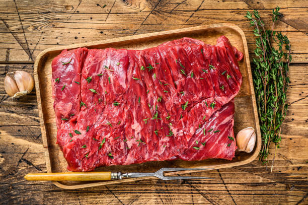 raw beef round cut meat on a wooden tray with herbs. wooden background. top view - circular skirt fotos imagens e fotografias de stock