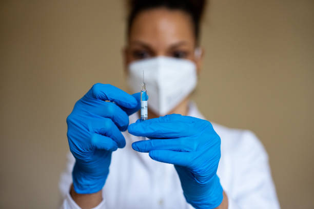 istock Woman preparing injection for covid-19 vaccination 1300724195