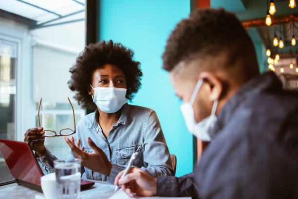 istock African-American business couple with protective face mask 1300724563