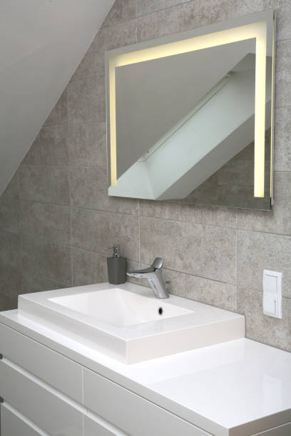 istock Illuminated mirror in new bathroom in gray colors 1300737508