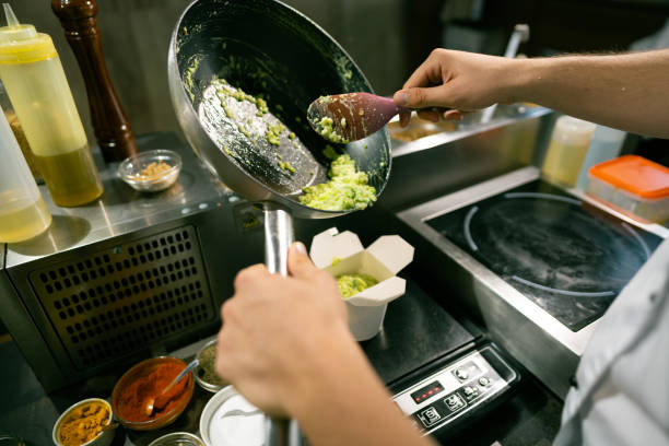 istock Male cook putting prepared dish in a takeaway box 1300739092
