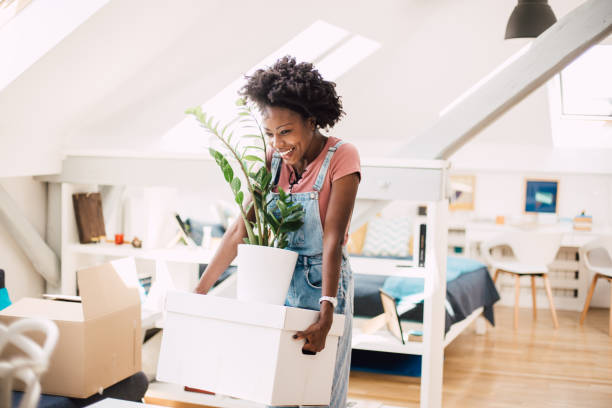 happy african-american woman moving into a new home - twenty first imagens e fotografias de stock