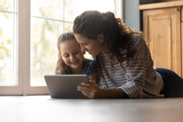 istock Happy mother and small daughter use pad gadget together 1300739220