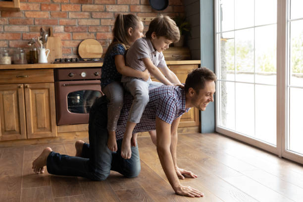 istock Happy kids play with young father at home 1300739222