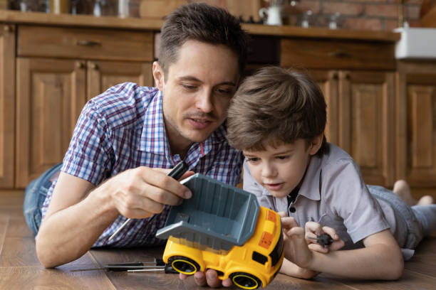 istock Loving dad have fun playing repairing car with small son 1300739225