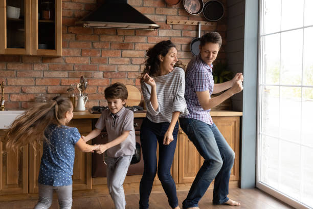 istock Overjoyed young family with kids dance in kitchen 1300739253
