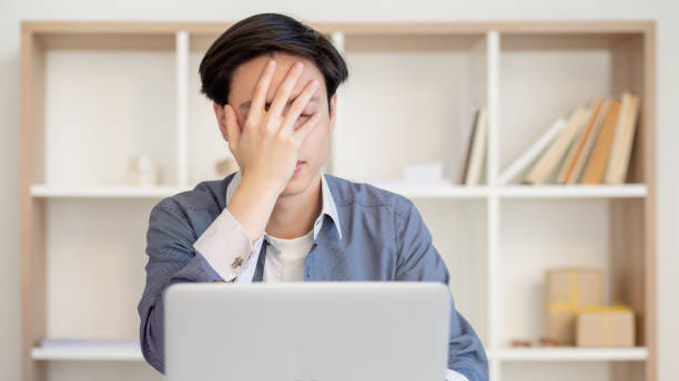 depressed office worker deadline pressure manager Depressed office worker. Deadline pressure. Professional anxiety. Disappointed ashamed asian project manager with laptop showing facepalm gesture. wtf stock pictures, royalty-free photos & images