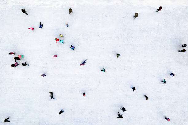 Winter fun. Ice skating top view. Children and their parents learn to skate on ice in winter. Ice skating top view. Children and their parents learn to skate on ice in winter. Winter fun. aerial view of people stock pictures, royalty-free photos & images