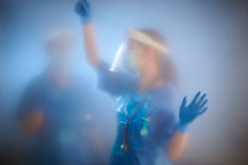 nurses behind quarantine enclosure