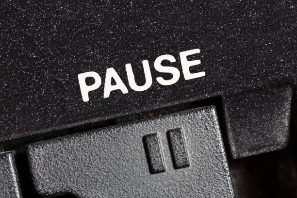 Macro close up photograph of vintage tape machine play and record pause button.