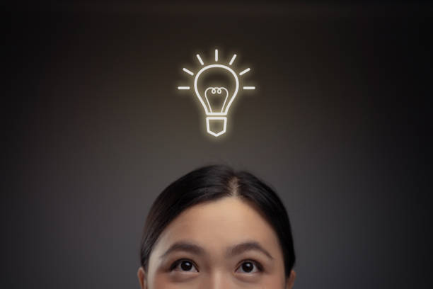 행복한 아시아 여성과 전구 아이콘 홀로그램 효과. - light bulb women inspiration surprise 뉴스 사진 이미지