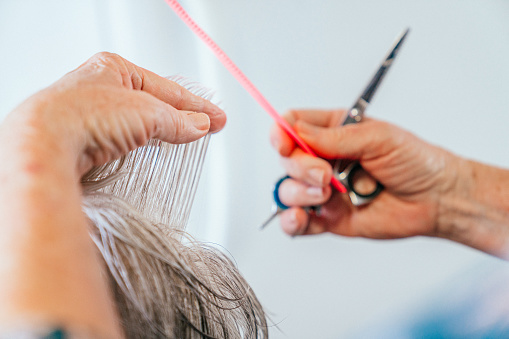 Close-Up Shot of a Professional Hair Stylist's Hands Cutting Old, Gray, Elderly Person's Hair