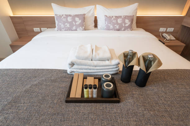 set van hotel voorzieningen (zoals handdoeken, shampoo, zeep, tandenborstel etc) op het bed. - hotel shampoo stockfoto's en -beelden