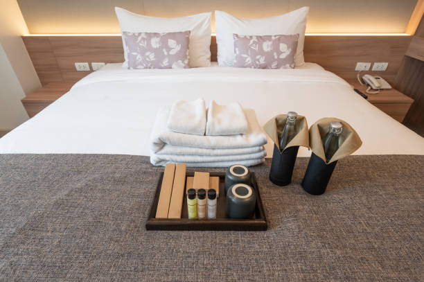 istock Set of hotel amenities (such as towels, shampoo, soap, toothbrush etc) on the bed. 1300757513