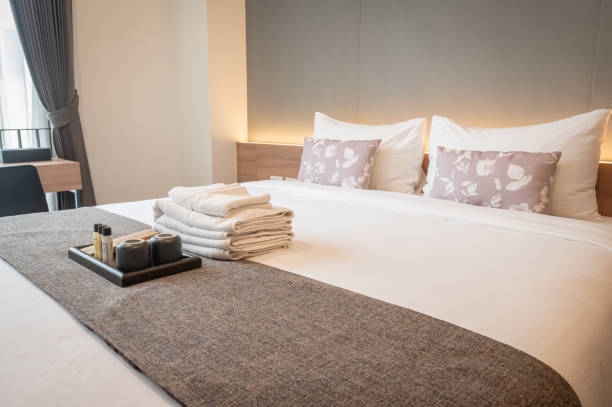 vista lateral de las comodidades del hotel (como toallas, champú, jabón, cepillo de dientes, etc.) en la cama. - cushion pillow textile luxury fotografías e imágenes de stock
