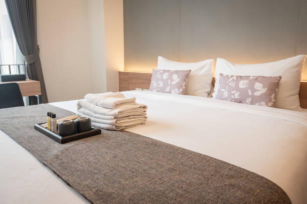 side view of hotel amenities (such as towels, shampoo, soap, toothbrush etc) on the bed. - estalagem imagens e fotografias de stock