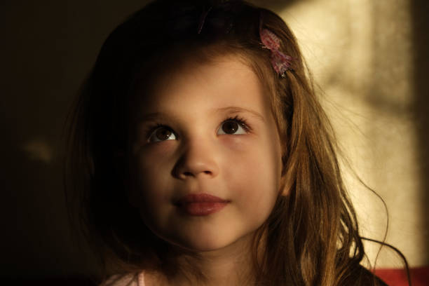 istock Little girl in dark side with shadow on face 1300758804